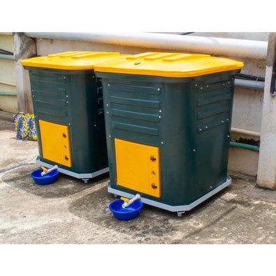 pair of Daily Dump Gaia OWC bulk composters outside apartment building for composting kitchen waste
